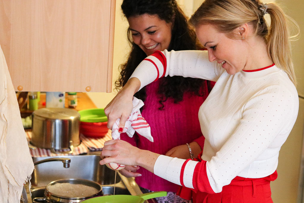 Hannah und Klarida von der besten Airbnb Entdeckung in Berlin beim Käse abschroepfen