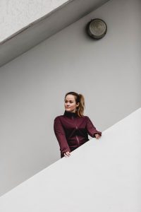 Jen steht auf einer Treppe im Running Outfit von Adidas