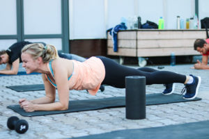 Junge Dame lacht beim Planken bei der 6 Wochen Challenge