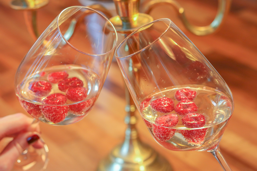 Rezeptidee fuer Valentinstagsmenue anstossen mit Sekt und Himbeeren