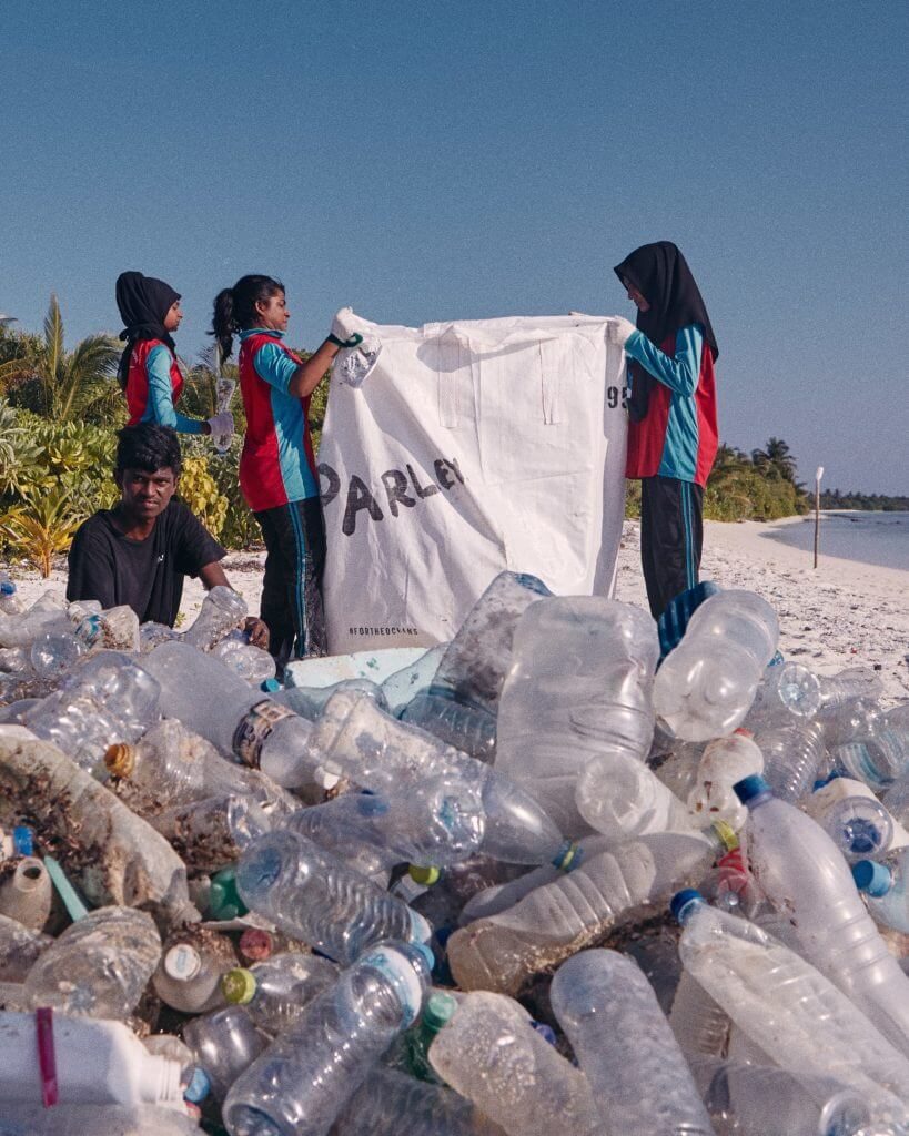 Jugendliche sammeln Plastikflaschen am Strand für Run for the Oceans