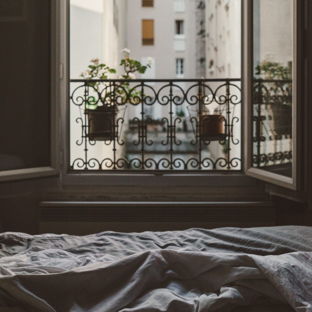 Paris von zu Hause, ein Bett vor einem Fenster in Paris