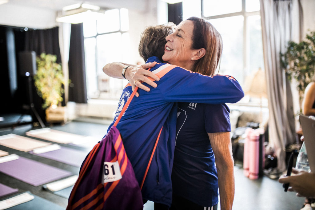 Kathrine Switzer bei Airbnb Entdeckungen Event für Berlin Marathon Umarmung