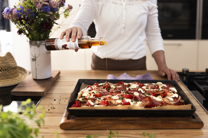 Selbstgemachte Pizza auf dem Blech angerichtet mit Bio Planete Pizza und Pasta Öl